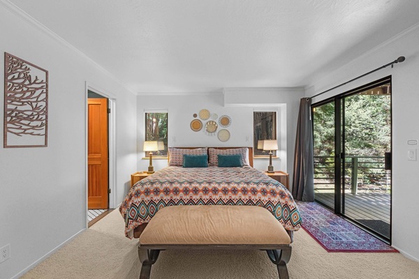 From the primary bedroom, step through the slider onto the deck or through the open door into the ensuite spa bath.