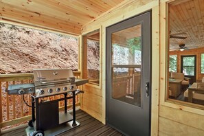 A wooden cabin with a barbecue grill outside, a sliding glass door, and a deck area. - Cozy Smoky Mountain Home 3BR/2BA walking distance from the Pigeon Forge Parkway (Pigeon Forge)