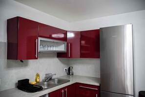A kitchen with red cabinets, a stainless steel refrigerator, a sink, and a dish rack. - Charming luxury villa near Disneyland Paris. 6 bedrooms. Air-conditioned. Sleeps 16 (Bussy-Saint-Georges)