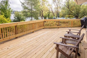 Eine Holzterrasse mit Blick auf einen See und Bäume.