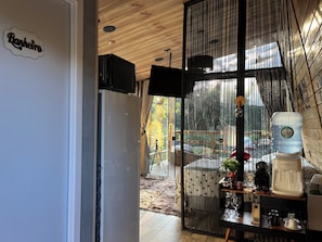 A kitchen with a wooden ceiling, a water dispenser, and a coffee machine on a counter. - My eucalyptus tree cabin - a little corner of paradise. (Alfredo Wagner)