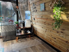 A wooden interior with a water dispenser, a coffee machine, and a small table with glasses and cups. - My eucalyptus tree cabin - a little corner of paradise. (Alfredo Wagner)