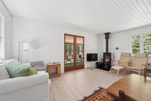Ein modernes Wohnzimmer mit einer Couch, einem Fernseher, einem Kamin und einem Essbereich.