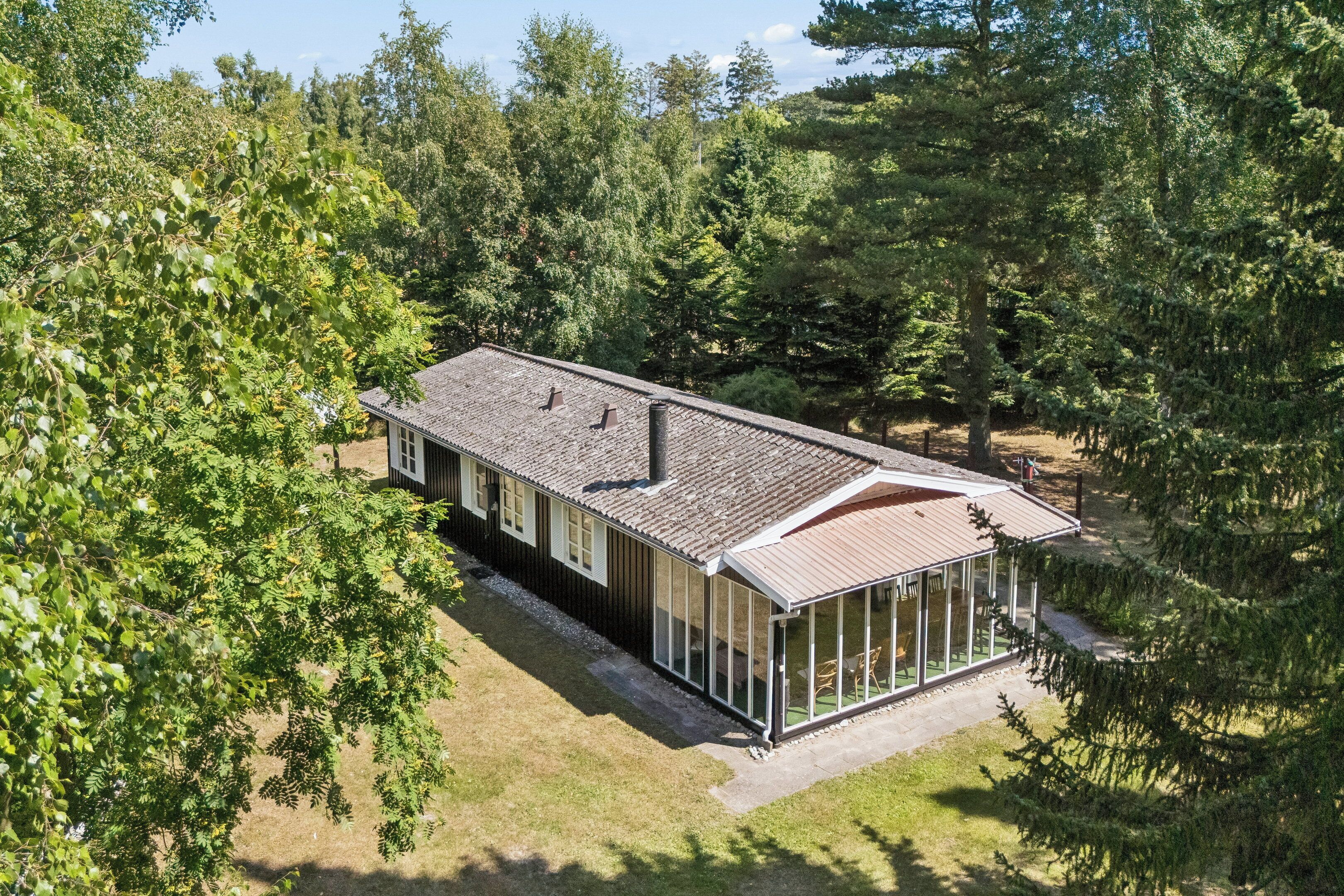A two-story house with a covered porch and a large windowed area.