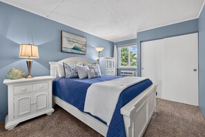 A bedroom with a bed, nightstands, a lamp, a picture on the wall, and a window. - Bayfront 1BR With Pool Near Beach (Ocean City)