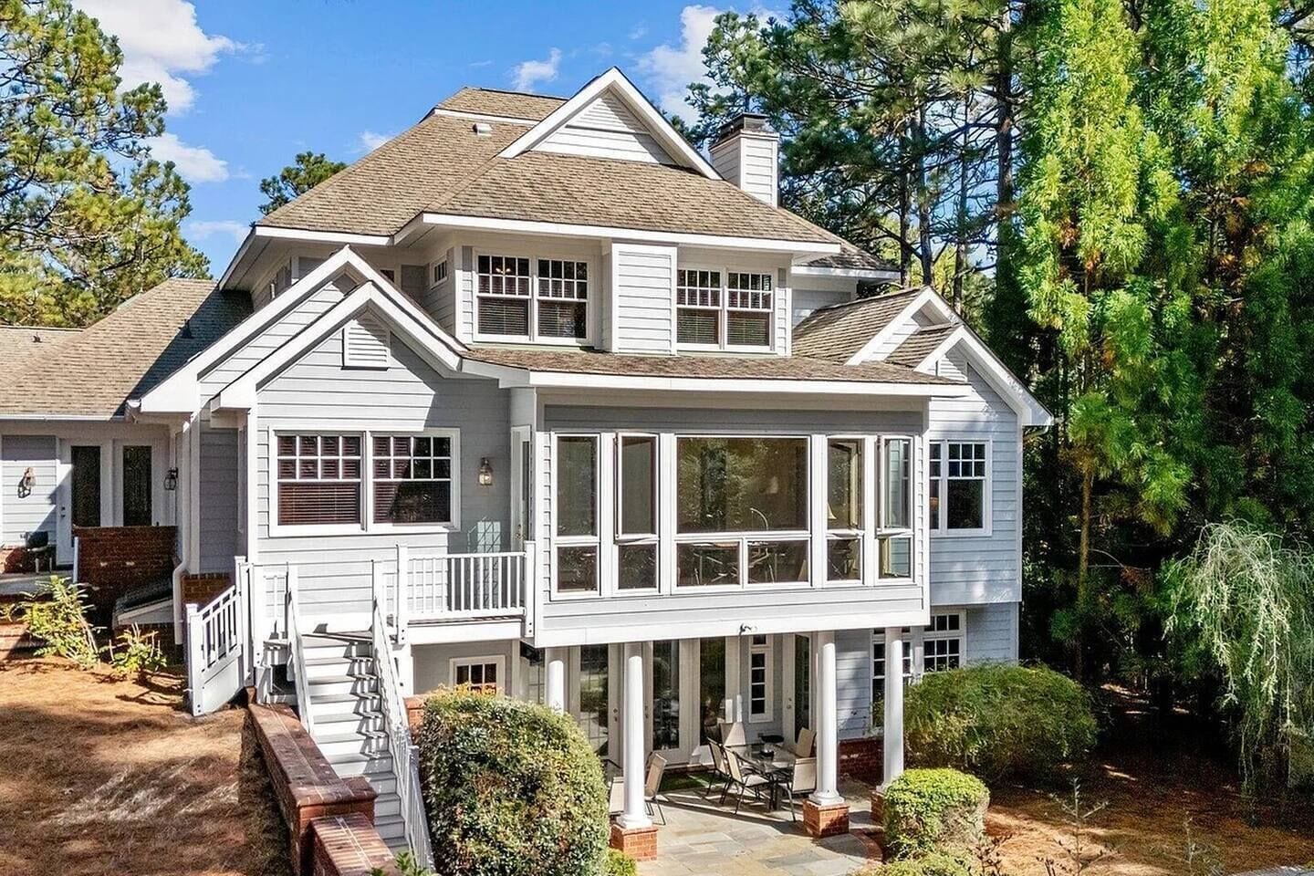 A two-story house with a covered porch, a chimney, and a landscaped yard.