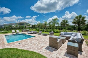 A backyard with a swimming pool, outdoor furniture, and a well-maintained lawn. -  Luxury Disney Escape Private Pool, Spa ,Game Room (Kissimmee)