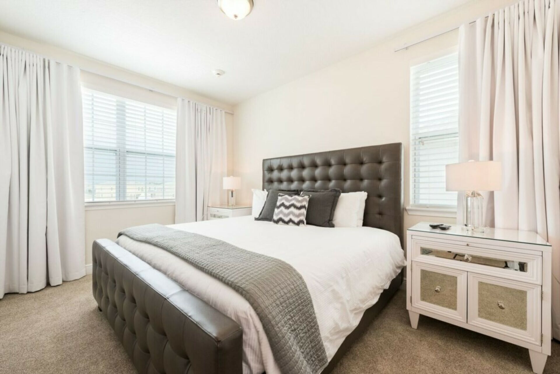 A bedroom with a large bed, a nightstand, and a dresser.