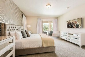 A bedroom with a large bed, a TV, a dresser, and a view of the outdoors. -  Luxury Disney Escape Private Pool, Spa ,Game Room (Kissimmee)