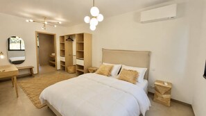 A bedroom with a bed, bedside tables, a hanging light fixture, a wardrobe, and a mirror. - Villa d'exception avec piscine -  Hauteurs d'Olmeto (OLMETO)
