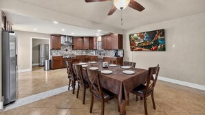 A spacious kitchen with a dining area, equipped with modern appliances and a ceiling fan. - Central San Antonio 3BR • PS5 • Sleeps 10 • Blue Yard Homes (San Antonio)