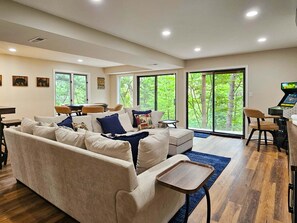 A modern living room with a sofa, a coffee table, and a gaming console. - Bear Lodge - Hot tub & Bryce Mountain views! (Basye)