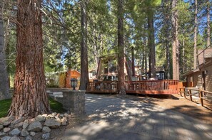 A lodge with a wooden deck, surrounded by tall pine trees. - Bearwoods Barn W Spa Near Snow Summit (Big Bear Lake)
