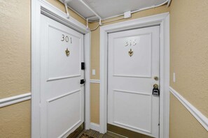 Two white doors with numbers 301 and 315, a white wall, and a beige floor. - Downtown Jacksonville Retreat | Walk to Events & Stadium (Jacksonville)