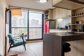 Eine moderne Küche mit großem Fenster, einem Essbereich mit Stuhl und einer Kücheninsel.