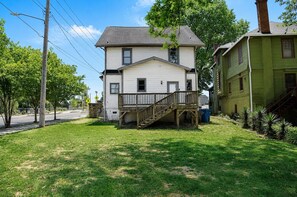 A two-story house with a front porch and a staircase leading to the entrance.