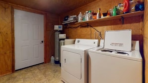 A laundry room with a washing machine, dryer, and shelves with cleaning supplies. - 4 Eagles | Hot Tub | South Fork Cabin | Wolf Creek (South Fork)
