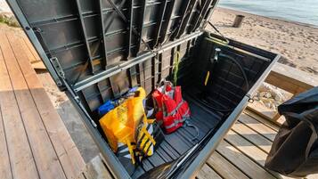 Un meuble de rangement en métal, avec un intérieur noir, contenant un sac jaune, un sac rouge et un sac noir.