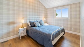 Een slaapkamer met een bed, nachtkastjes en een raam.