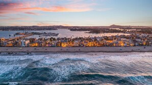 Paisatge urbà costaner amb un port esportiu, edificis a primera línia de platja i vista a l'oceà.