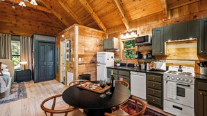 Ein gemütliches Blockhaus-Interieur mit Essbereich, Küche und einem Bett.