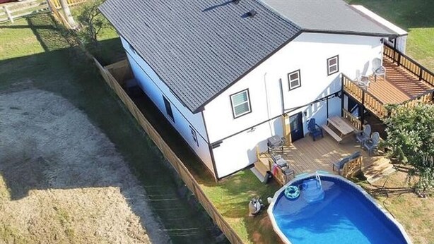 A two-story house with a deck, a swimming pool, and a fenced yard. - Holds 8 · Pool · 3BR/2BA Lower-Unit Duplex Peacock Horse Beach NearbyOut of City (Galveston)