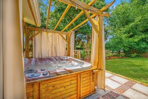 A hot tub with wooden benches and a pergola structure. - Main house and guest house, Events, Heated Pool 15min to Clw Beach (Clearwater)