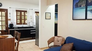 A compact living space with a kitchenette, dining area, and a sofa. - Feet in the Sand / Beach House / Bertioga (Bertioga)
