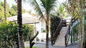 A paved pathway with palm trees, a staircase, and a building in the background. - Feet in the Sand / Beach House / Bertioga (Bertioga)