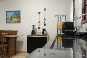 A kitchen with a coffee maker, a blender, and a coffee machine on the counter.