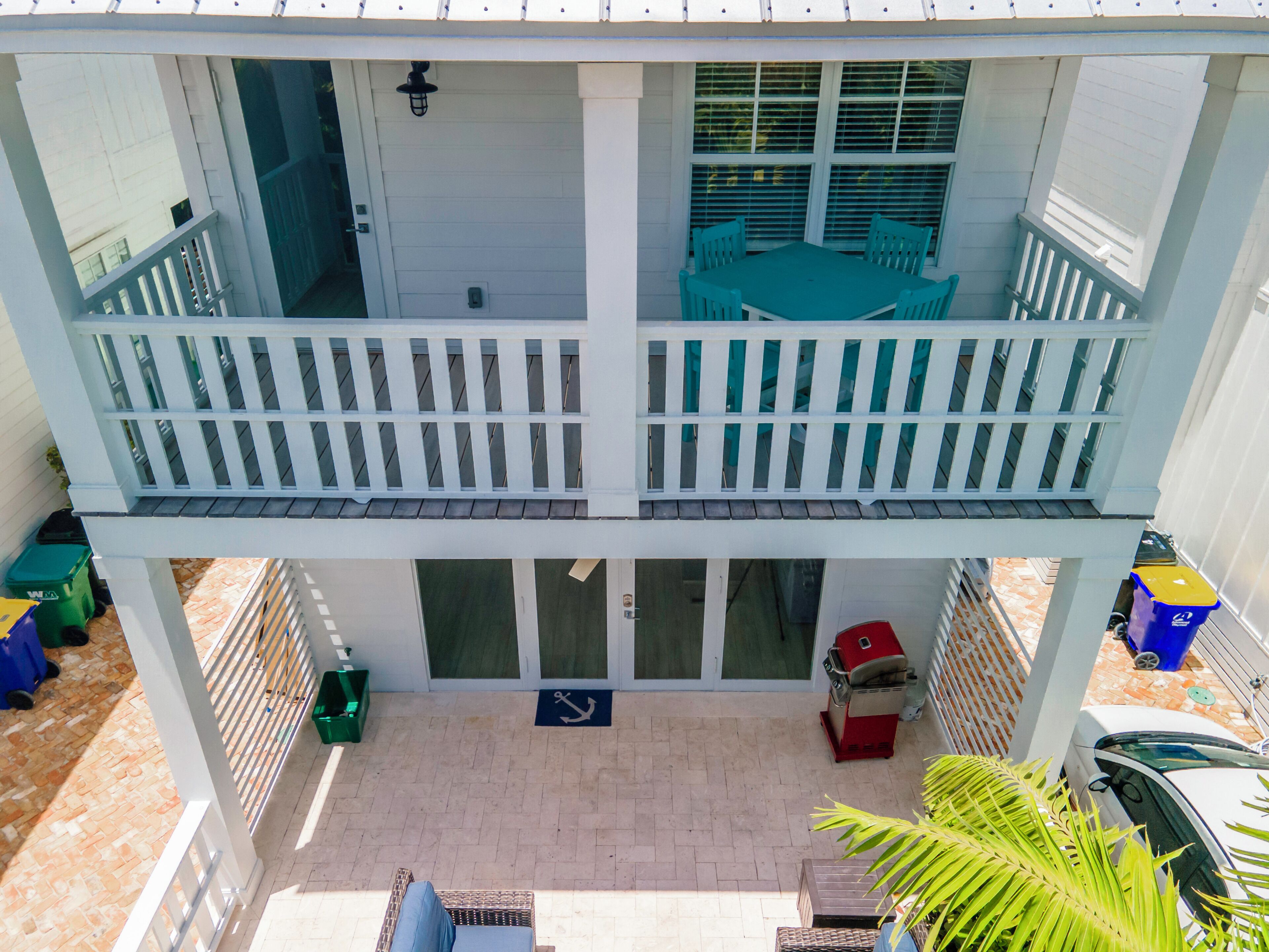 A two-story building with a balcony, a patio area, and a sliding door.