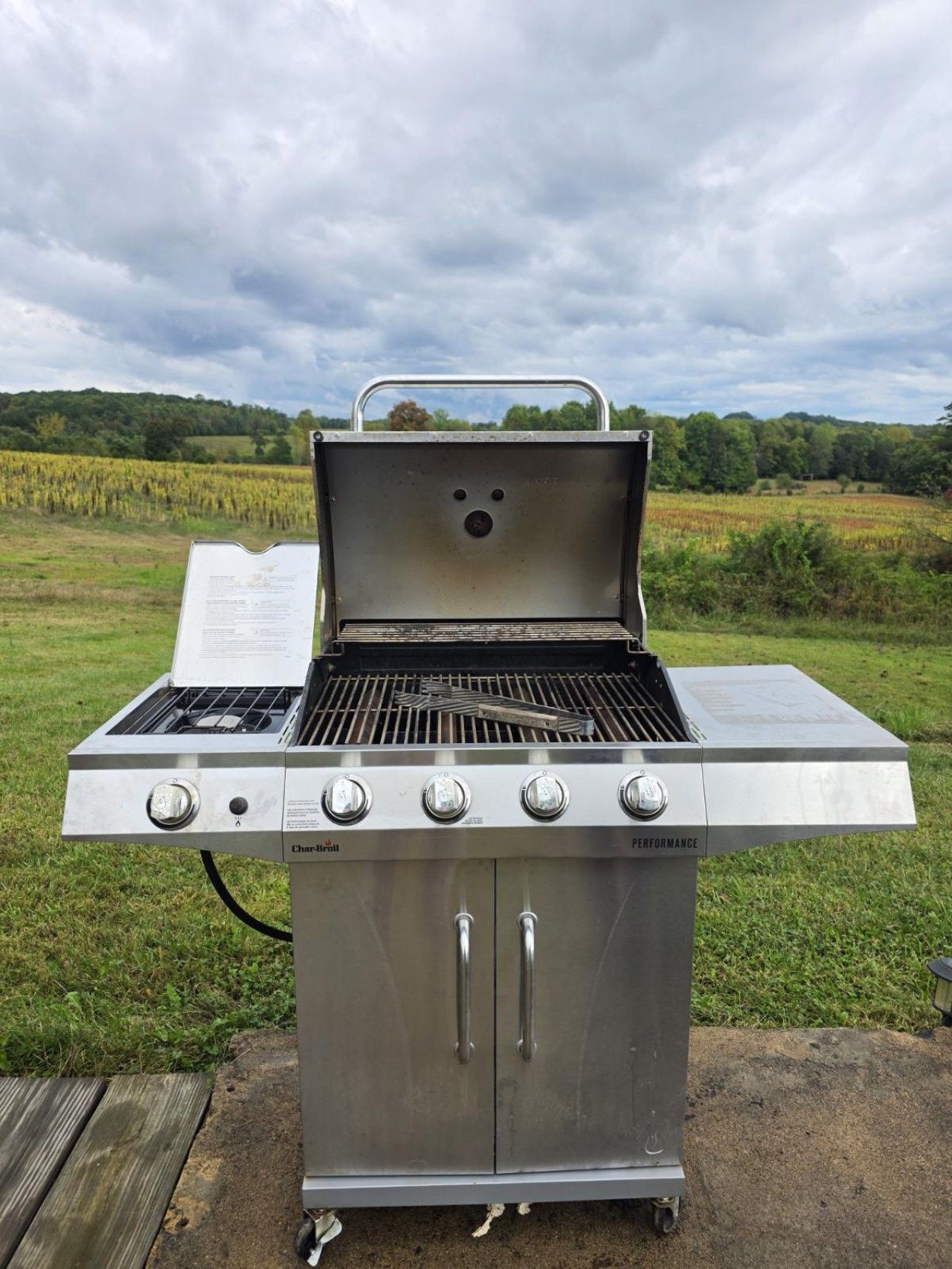 Un barbecue à gaz Char-Broil doté de quatre brûleurs, d’un brûleur latéral et d’une cheminée.