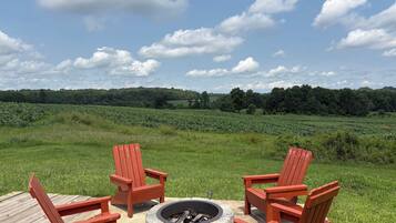 Four Adirondack chairs around the fire pit