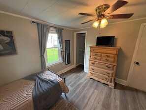 A bedroom with a bed, a dresser, a ceiling fan, and a window. - Cozy Country Cottage | 10 Min to Downtown Elkin (Elkin)