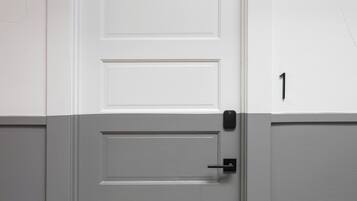 A white door with a black handle and a number '1' on the adjacent wall.