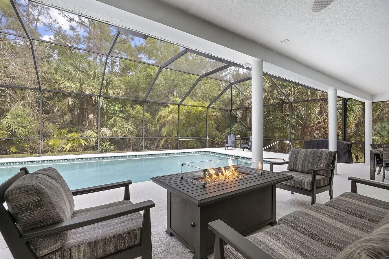 Une terrasse extérieure avec une piscine, des sièges et un foyer.