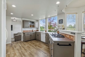 Una cocina moderna con una isla grande, armarios empotrados y vistas al exterior.