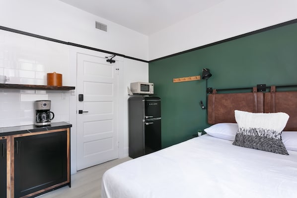 A hotel room with a bed, a coffee machine, a microwave, and a wardrobe. - La Ventana Hotel - Renovated Room Steps from Gaslamp Quarter (San Diego)