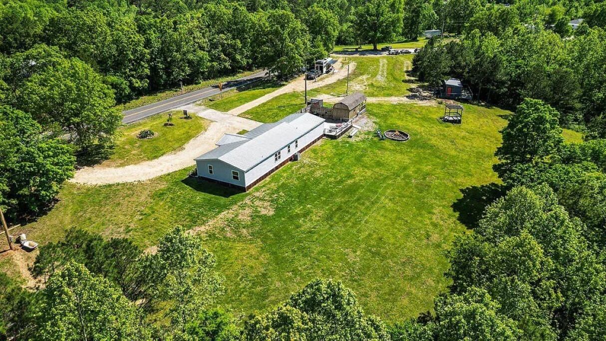 A single-story building with a flat roof, surrounded by a well-maintained lawn and trees.