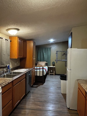 A compact kitchen with wooden cabinets, a sink, and a refrigerator. - Your Own Private Storybrook Retreat

Everyone can gather! (Pineville)
