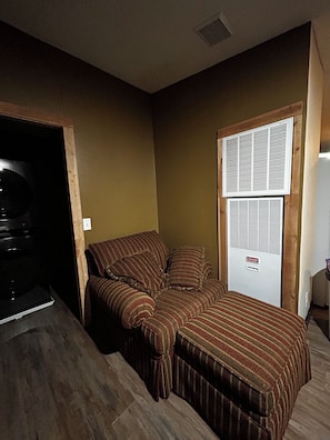 A room with a sofa bed, a vented wall unit, and a door with a window. - Your Own Private Storybrook Retreat

Everyone can gather! (Pineville)