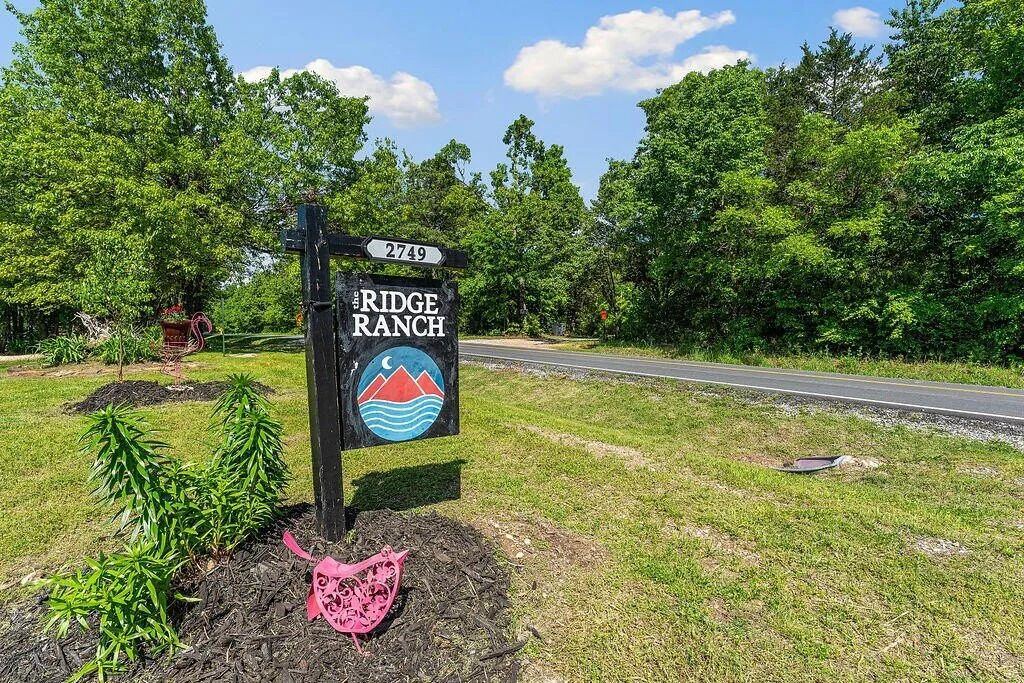A road sign for 'The Ridge Ranch' with a number '2749' and a logo featuring a mountain and waves.