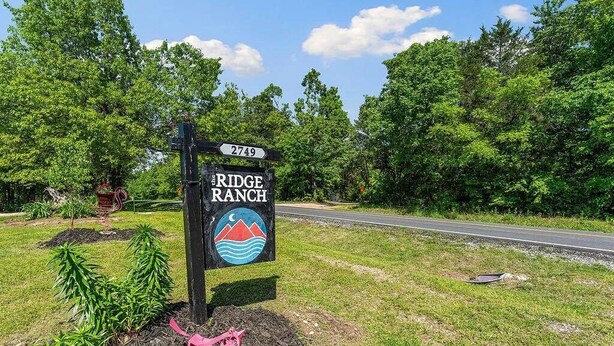 A road sign for 'The Ridge Ranch' with a number '2749' and a logo featuring a mountain and waves.