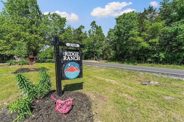 A road sign for 'The Ridge Ranch' with a number '2749' and a logo featuring a mountain and waves.