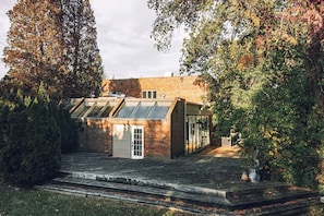 Un bâtiment moderne doté d’un toit en pente, d’un garage et d’une entrée avec une porte en verre.