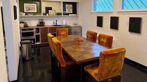 A dining area with a wooden table, four chairs, a coffee machine, and a kitchen in the background. - Lovely 2-bedroom apartment in Anchorage perfect for your getaway (Anchorage)