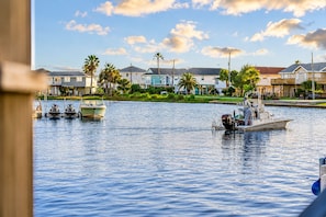 A marina with boats docked, surrounded by residential houses and palm trees. - Jamaica Beach | Hot Tub | Canal front Dock (Jamaica Beach)