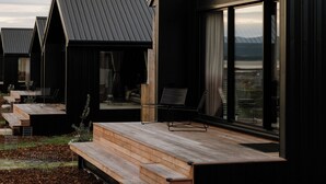 Una hilera de cabañas modernas con amplias ventanas y terraza de madera.
