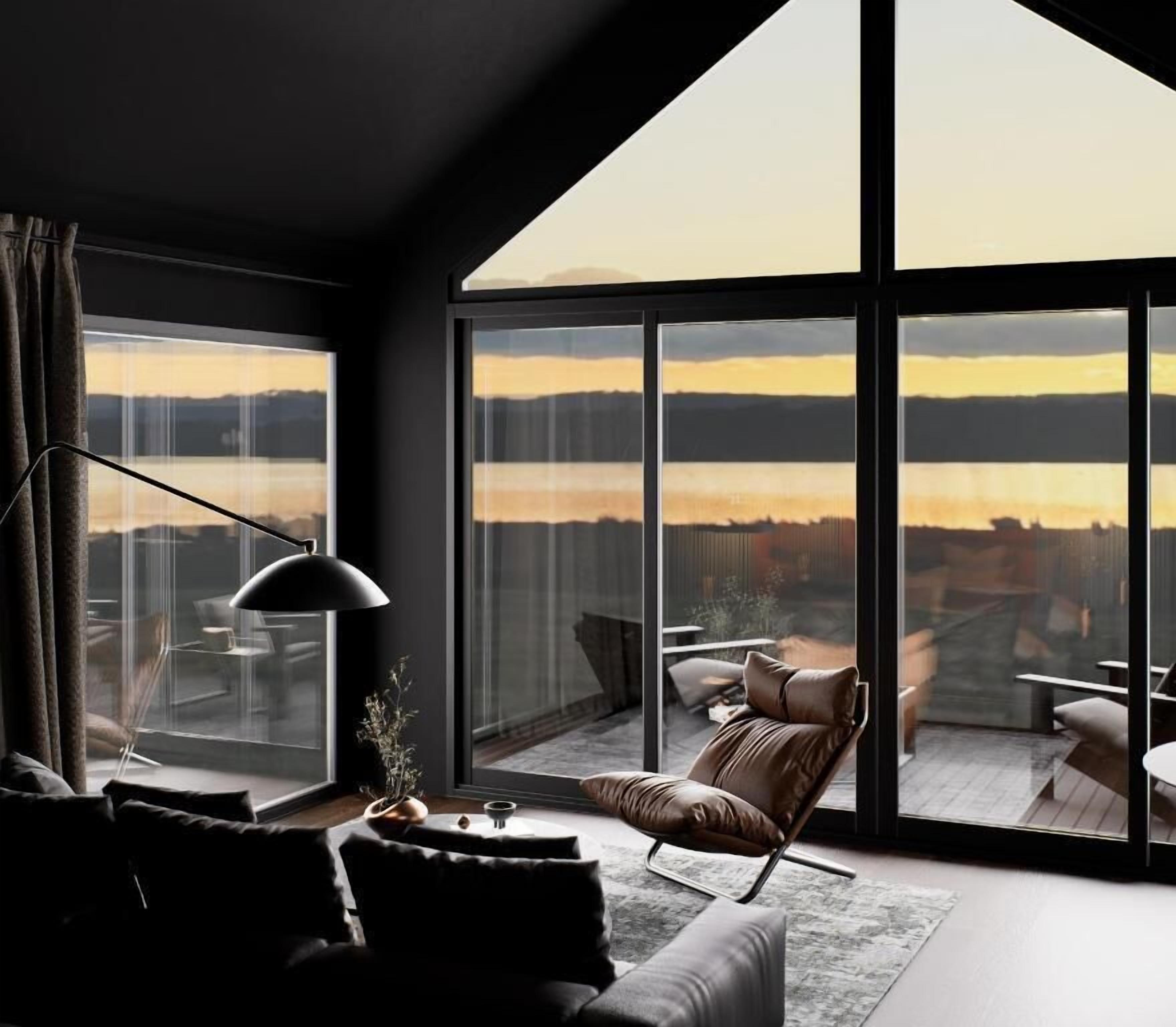 A modern living room with a large window, a sofa, a chair, and a table.