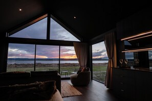 Een modern interieur met een groot raam met uitzicht op een waterpartij.